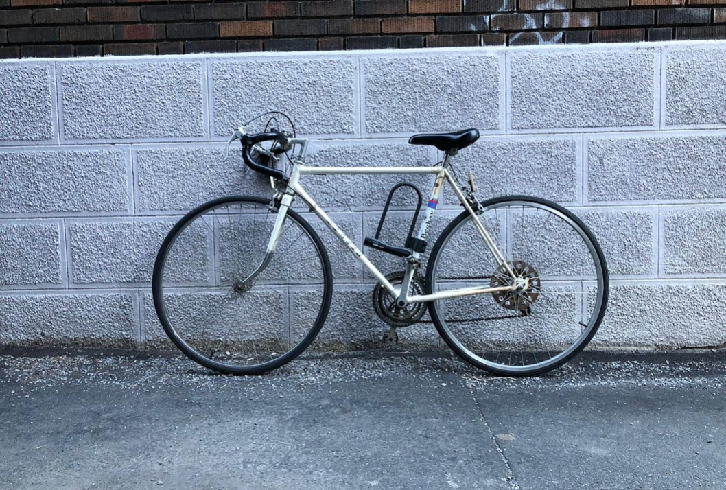 a white bike against a grey cement-block background